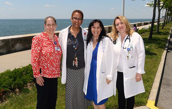 Group of Doctors Standing Outside in Front of Body of Water