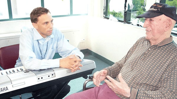 Man at Keyboard Listening to Elderly Patient
