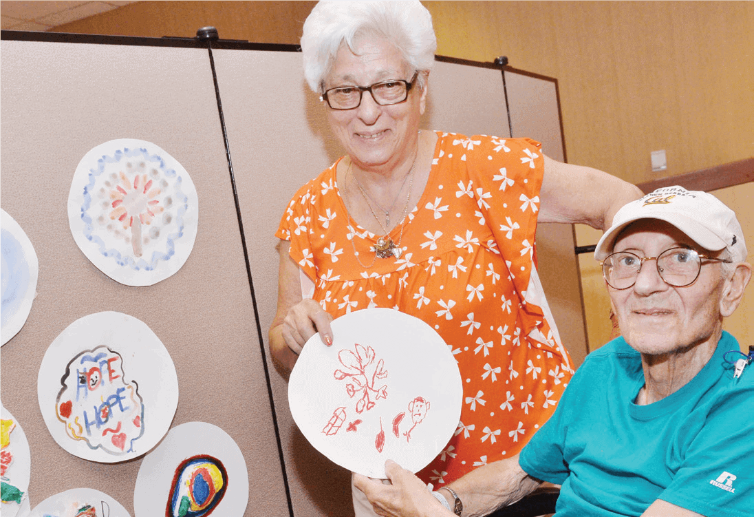 Enriching Therapies Elderly Couple Holding Paper Plate Artwork for Camera