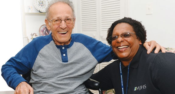 Older man and woman smiling in an embrace