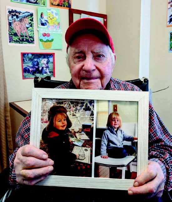 Older man holding up a picture