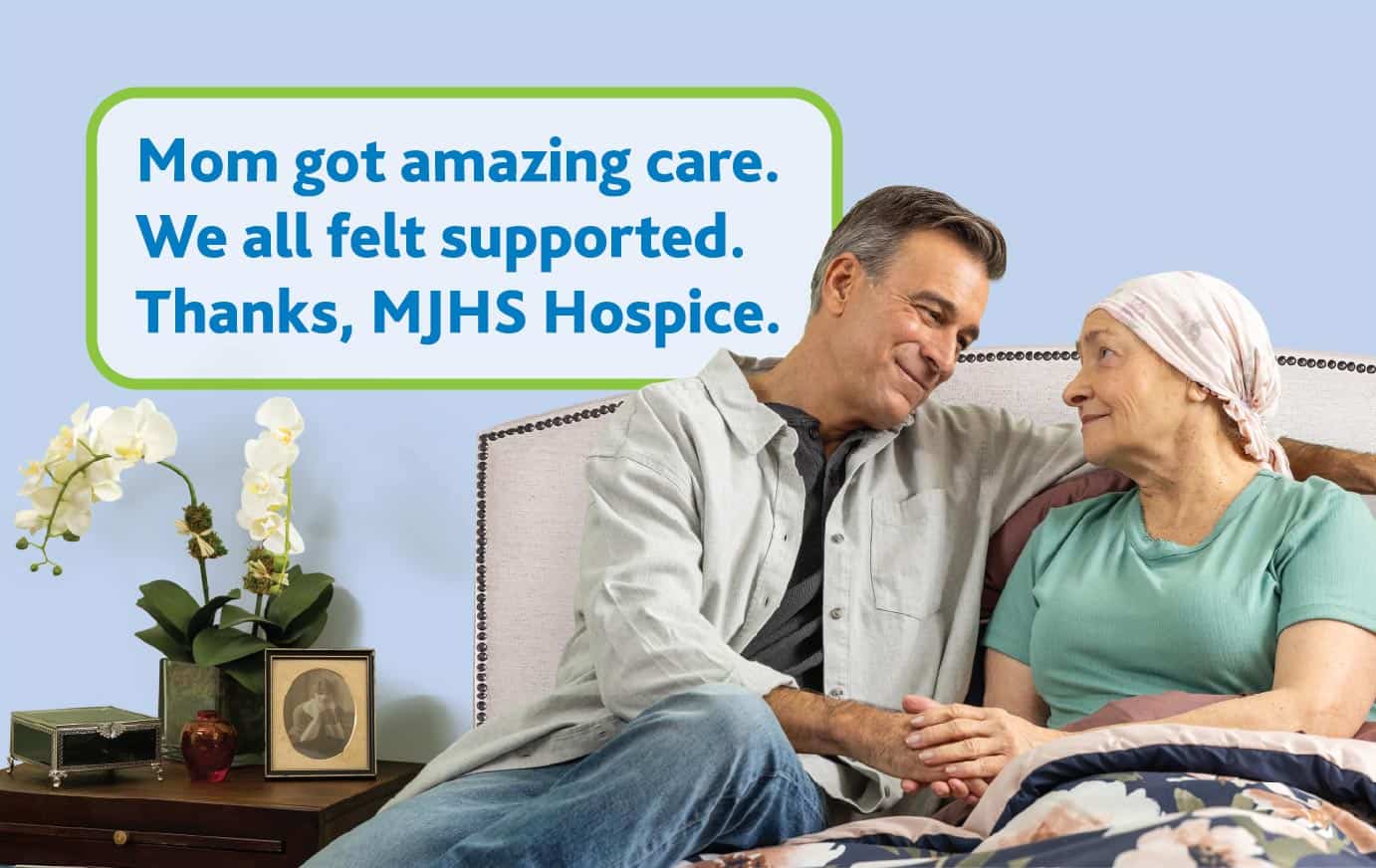 A man sits on a bed next to his mother. Text on the image reads, "Mom got amazing care. We all felt supported. Thanks, MJHS Hospice."