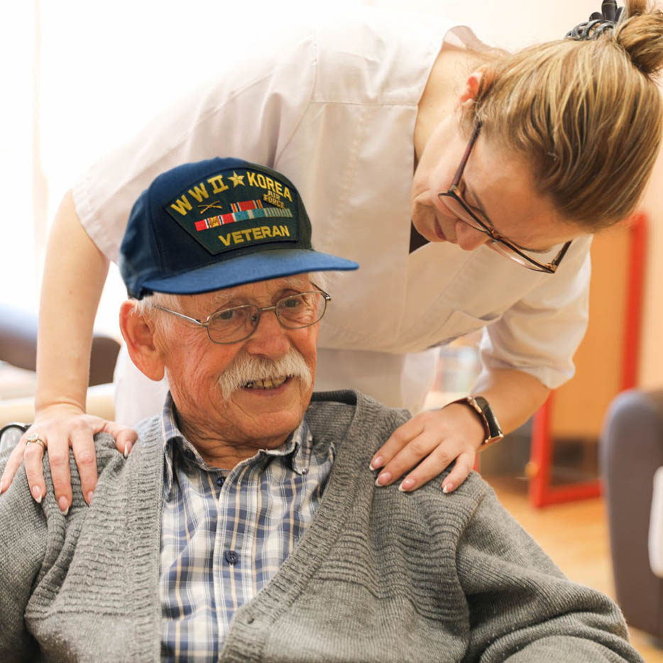 A smiling elderly veteran wearing a 