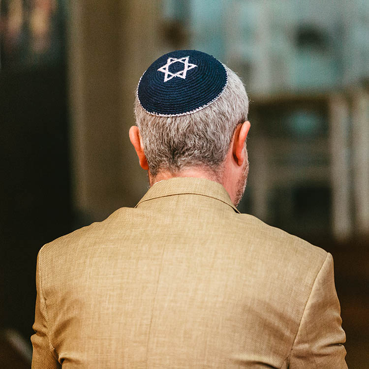 Back view of a man wearing a blue kippah with a white Star of David.